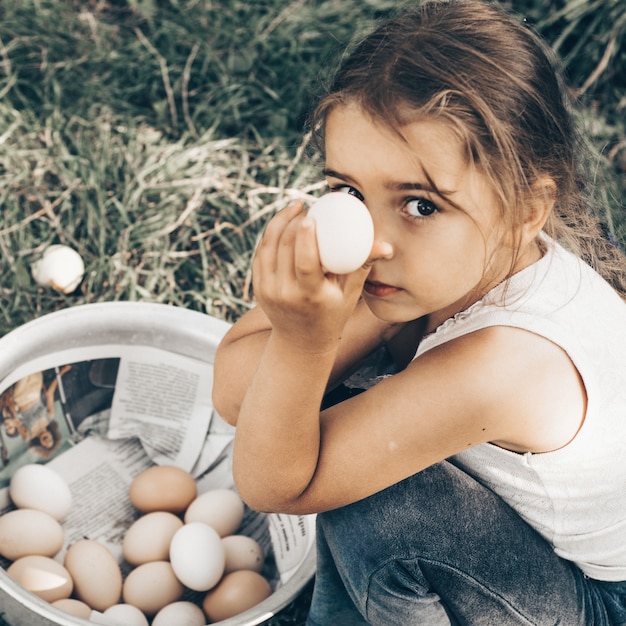 Little girl holding and picking good eggs quality organic and bring to the eye on the farm.