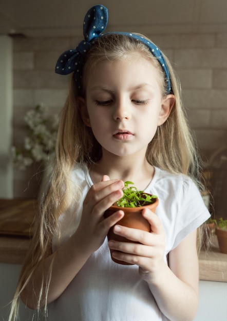 Little girl holding a pot of seedlings