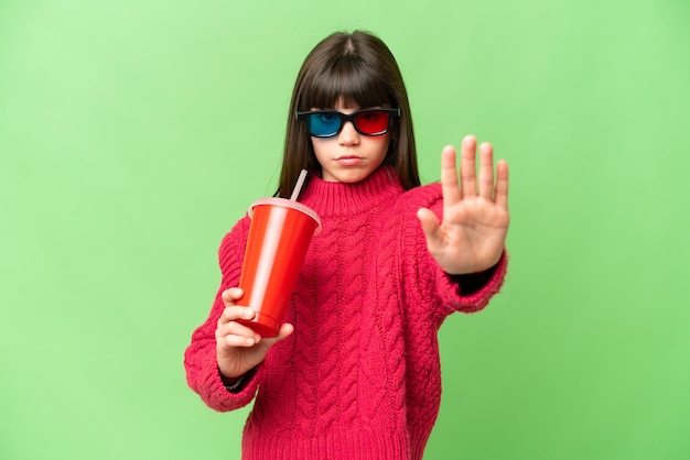 Little girl holding soda over isolated chroma key background making stop gesture