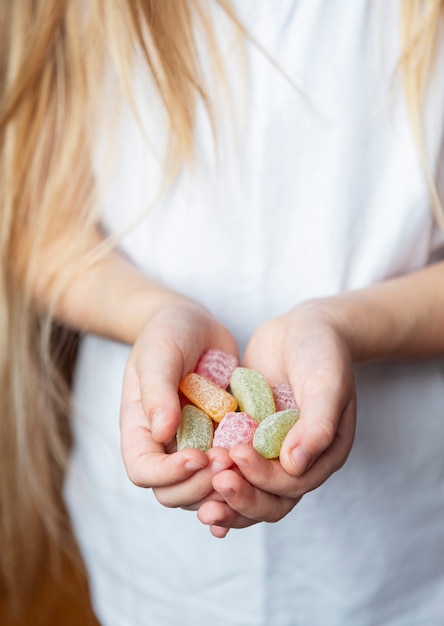 Little girl holding sweet candies in her hands