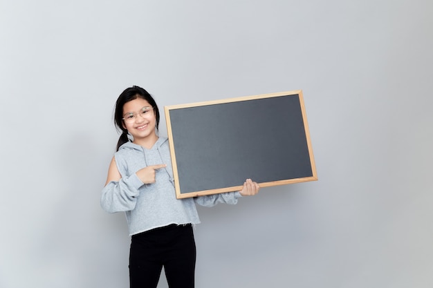 A little girl holds a blank chalkboard