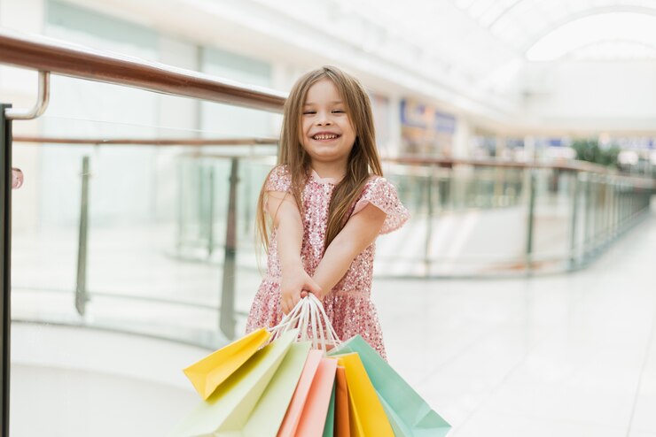 Photo a little girl holds multi-colored pastel bags in her hands.