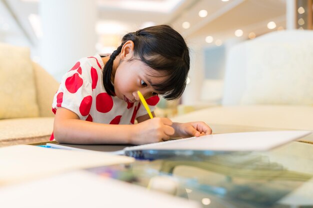 Little girl do homework write on book