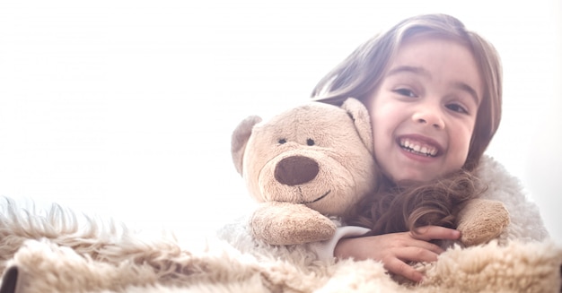 Little girl hugging bear toy