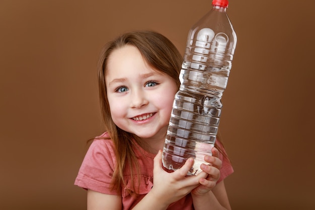 Bambina che abbraccia una bottiglia d'acqua