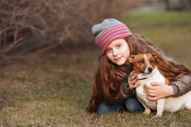 彼女の友人を屋外で犬を抱いて少女。友情、動物保護、ライフスタイルのコンセプト。