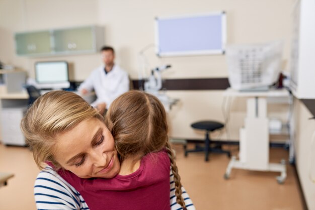 Little Girl Hugging Mom in Doctors Office