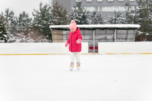 Bambina che pattina sul ghiaccio sulla pista di pattinaggio