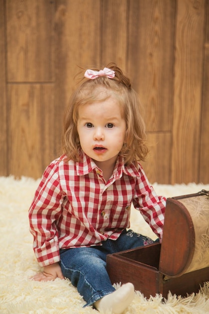 Фото Маленькая девочка в рубашке сидит с шкатулкой для драгоценностей