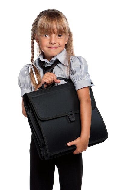 Фото Маленькая девочка в школьной форме с портфелем, изолированным на белом фоне