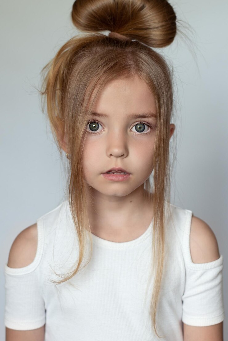 The little girl is angry , the child is at a loss on a white and gray background