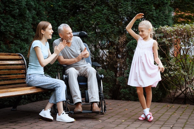 小さな女の子が踊っている、老人と女性が笑っている