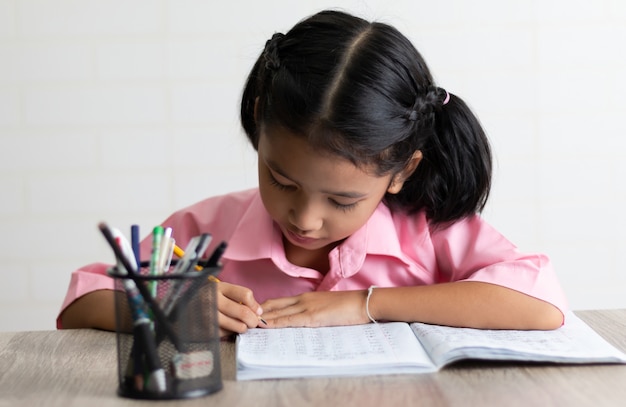 Photo little girl is doing homework intently