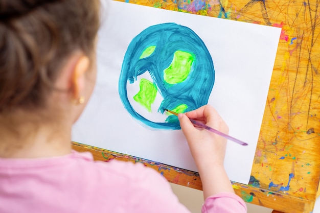 Photo little girl is drawing earth