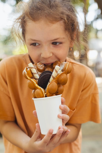 The little girl is enjoying a Belgian waffle