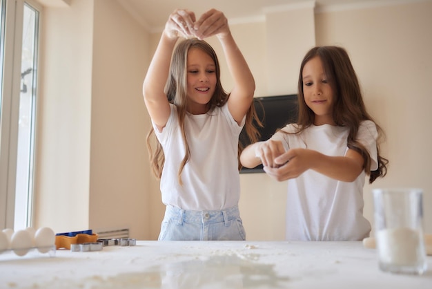 Little girl is helping to bake in a messy kitchen