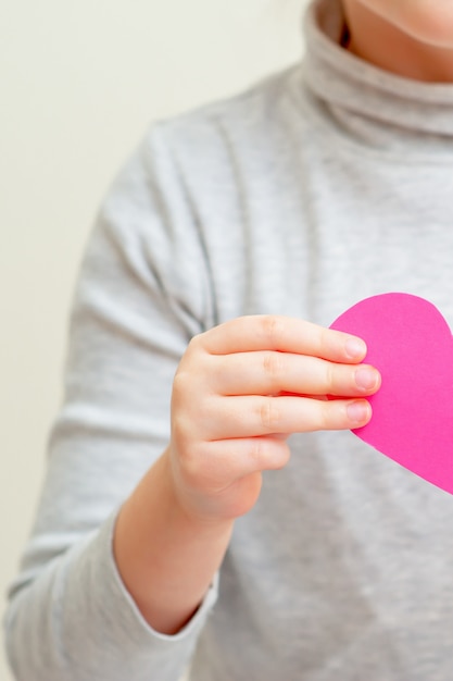 Little girl is holding pink heart