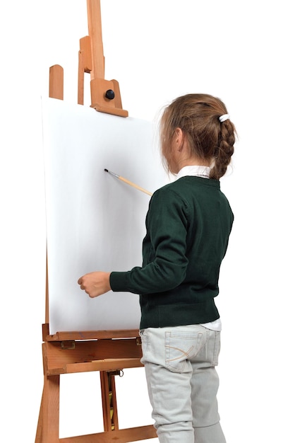 Little girl is painting on easel