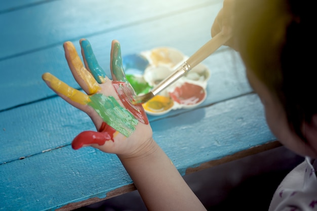 Photo little girl is painting her hand