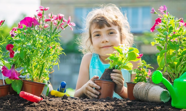 小さな女の子が花を植えています若い庭師セレクティブフォーカス自然