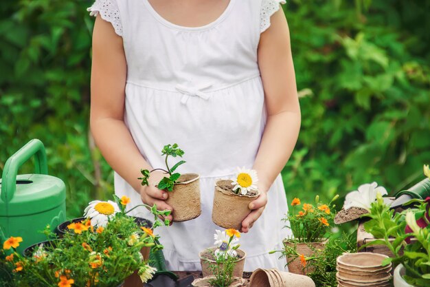 小さな女の子が花を植えています。若い庭師セレクティブフォーカス