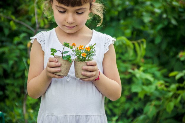 小さな女の子が花を植えています。若い庭師セレクティブフォーカス