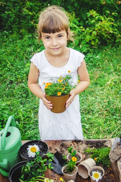 小さな女の子が花を植えています。若い庭師セレクティブフォーカス