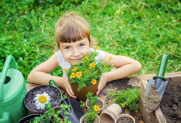 小さな女の子が花を植えています。若い庭師セレクティブフォーカス