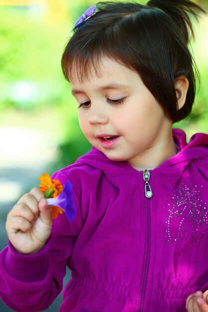 Little girl is playing in nature and smiling.