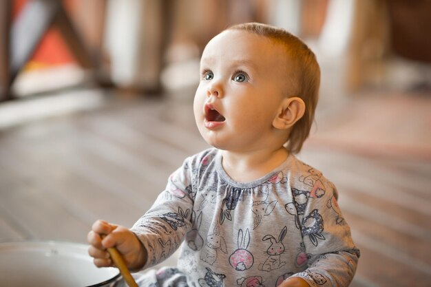 小さな女の子が大きな鍋と柄杓で遊んでいる 3455