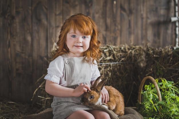 Little girl is playing with a red rabbit 6039