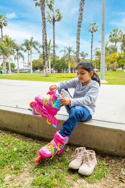 Little girl is putting on her roller skates