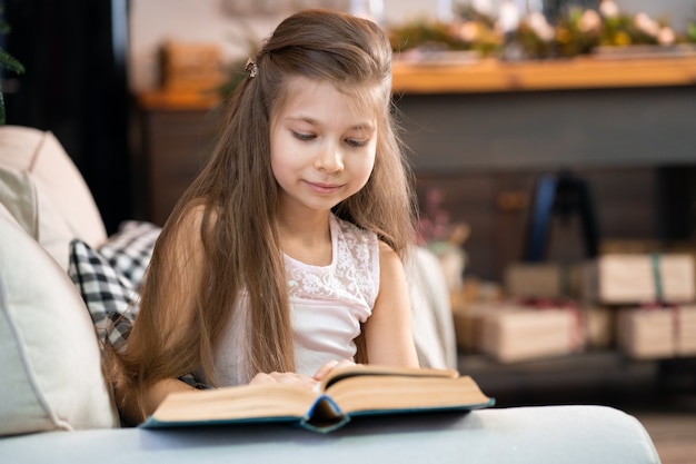 A little girl is reading an interesting book