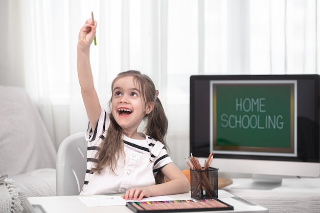 La bambina sta studiando a casa sorridente. concetto di istruzione domestica.