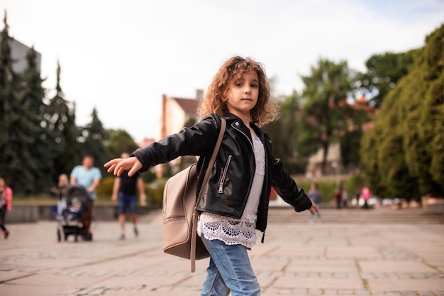 La bambina sta passeggiando per la città con una borsa