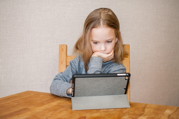 어린 소녀가 온라인 비디오 자습서를보고 있습니다. 원격 교육. 블로그. 고품질 사진