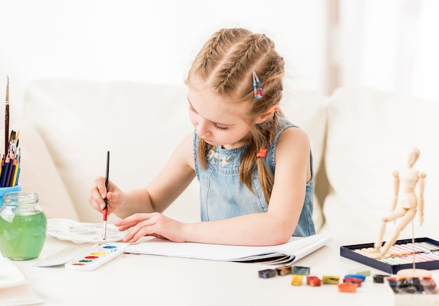 Little girl isdraws with watercolors