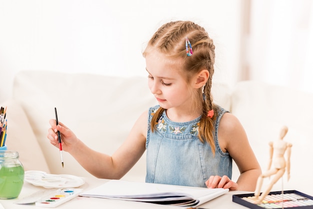 Little girl isdraws with watercolors