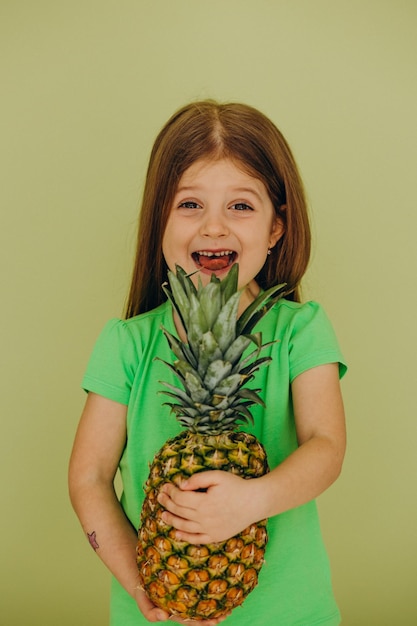 Little girl isolated holding pineapple