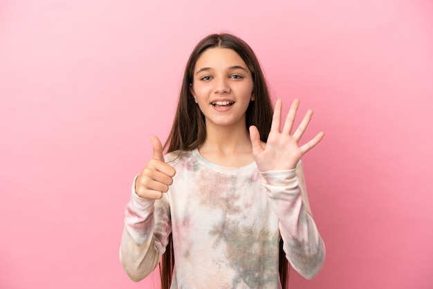 Little girl over isolated pink background counting six with fingers