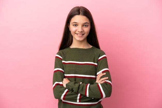 Little girl over isolated pink background keeping the arms crossed in frontal position