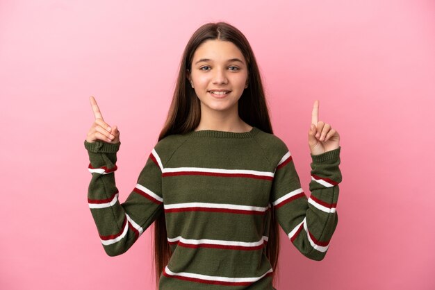 Photo little girl over isolated pink background pointing up a great idea