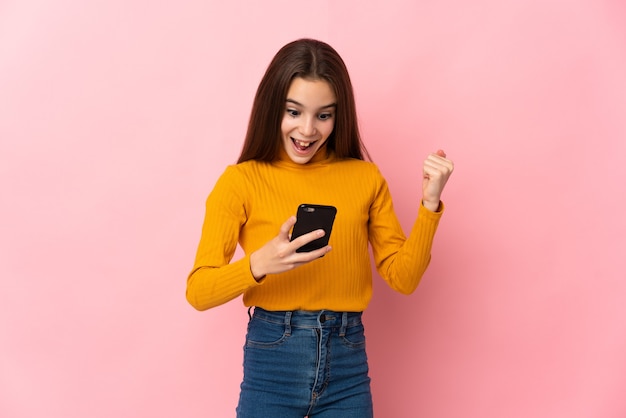 Little girl isolated on pink background surprised and sending a message