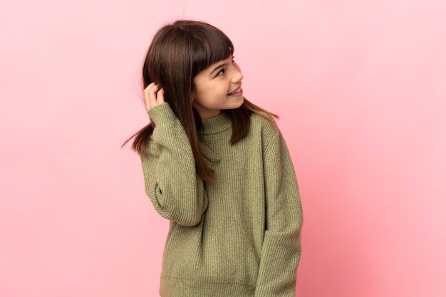 Little girl isolated on pink background thinking an idea