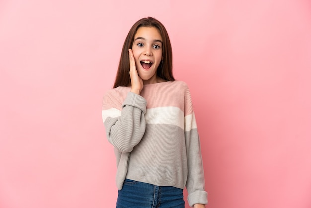 Little girl isolated on pink background with surprise and shocked facial expression