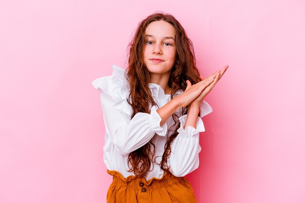 Little girl isolated on pink wall feeling energetic and comfortable, rubbing hands confident