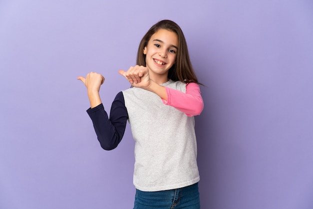 Little girl isolated pointing to the side to present a product