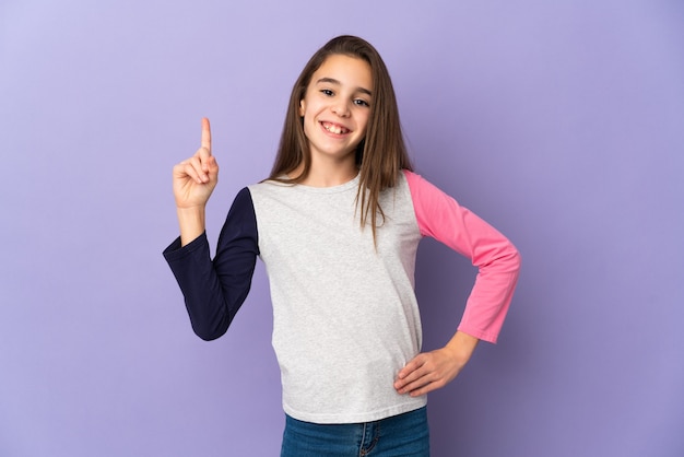 Little girl isolated on purple wall showing and lifting a finger in sign of the best