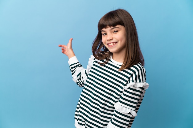 Little girl over isolated wall pointing back