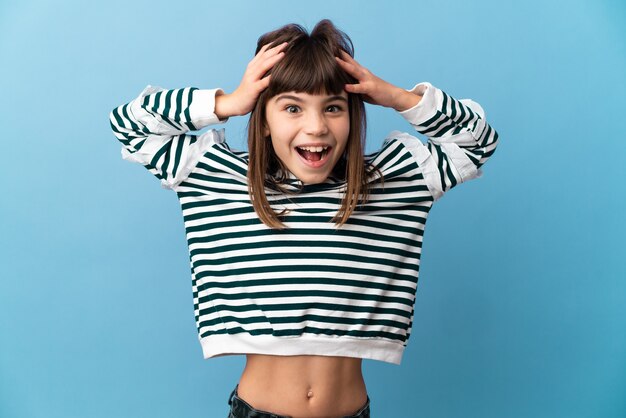 Little girl over isolated wall with surprise expression